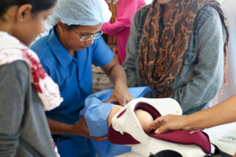 A midwife delivers a baby during a simulation in India
